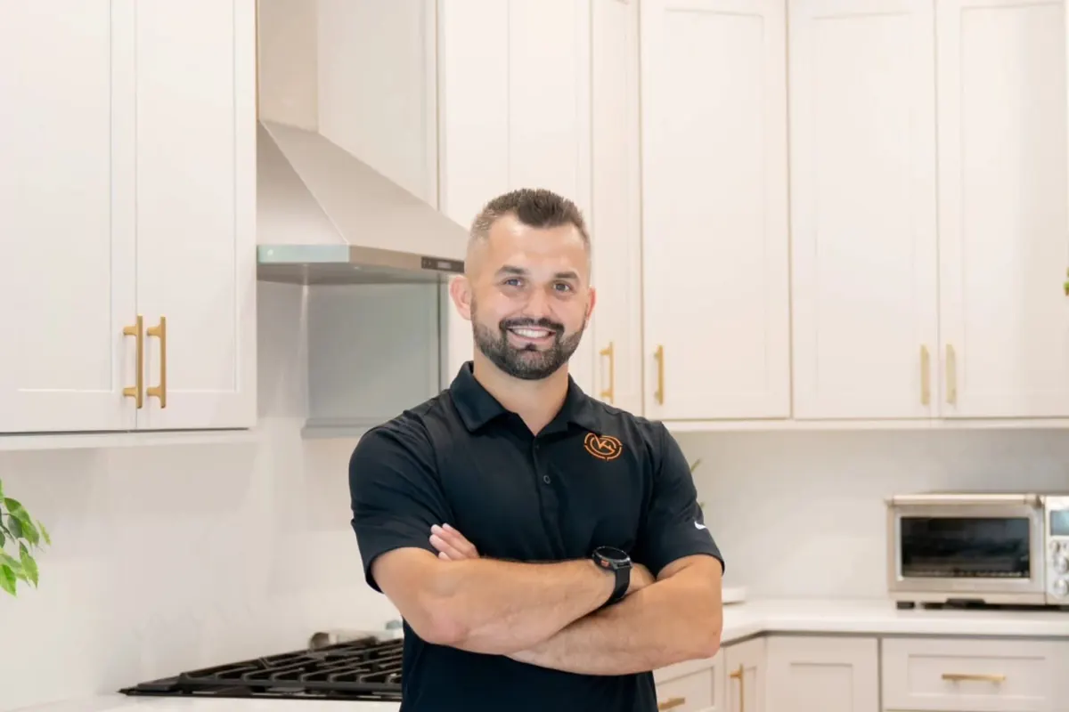 Sergey, the owner, standing in a finished white kitchen